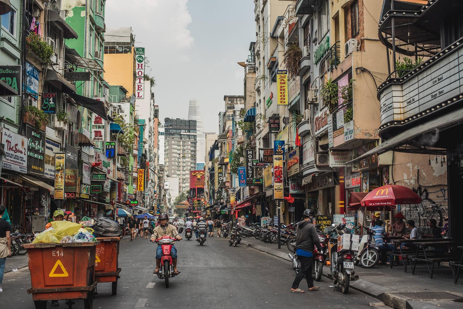 Belebte Straße mit Motorrollern und Geschäften in Ho-Chi-Minh-Stadt – Symbolbild für Auswandern nach Vietnam